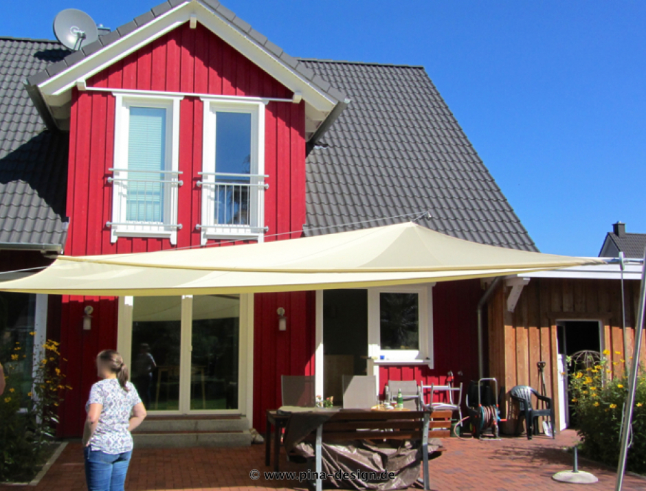 Sonnensegel manuell Weyhe 2M / 2 W in elfenbein vor roten Haus