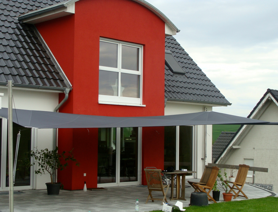 Sonnensegel - elektrisch - in Westfalen in anthrazit vor rot-weißem Haus