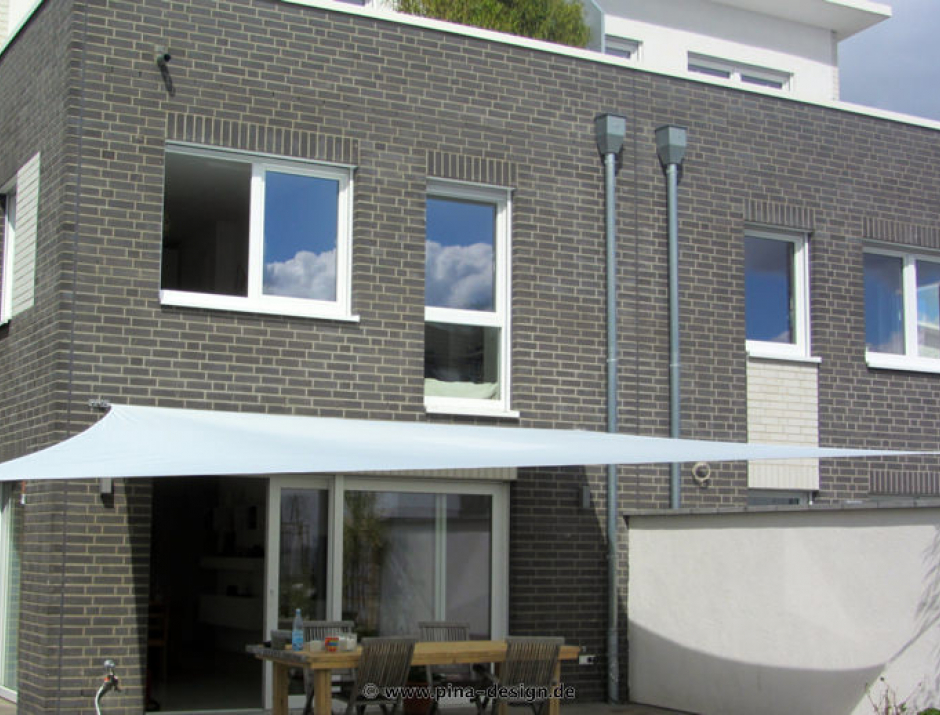 Sonnensegel feststehend Köln 2M / 2W II. weißes Segel vor einem grauen Haus