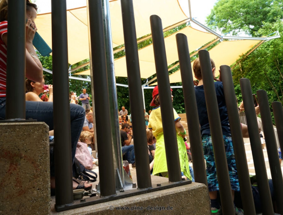 Sonnensegel feststehend Basel 4W II. Sonnensegel feststehend Basel 4M II gelbes Segel über einer Tribüne