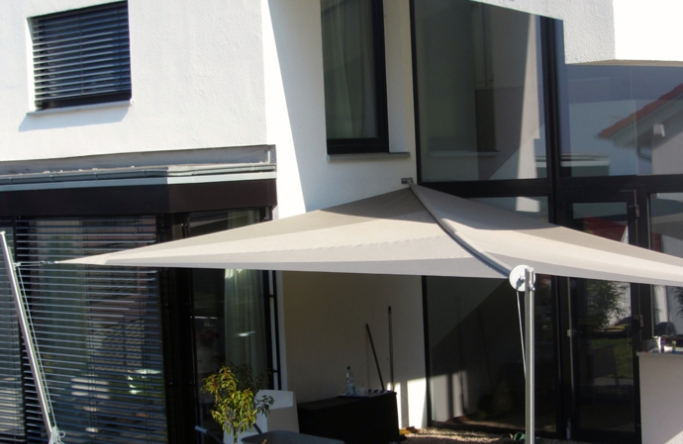 Sonnensegel manuell Bovenden 3M / 1W II. anthrazites Segel vor einem weißen Haus