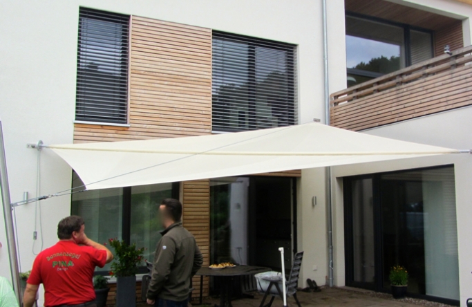 Sonnensegel manuell Bovenden 1M / 3W III.   in elfenbein vor einem Haus