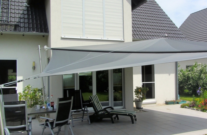 Sonnensegel manuell Hamm 3M / 1W II. graues Segel vor einem Haus