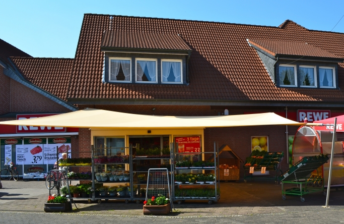 Sonnensegel - elektrisch - in Ascheberg in Gelb vor Supermarkt