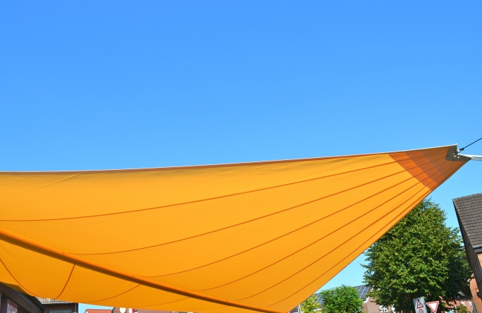 Sonnensegel - elektrisch - in Ascheberg in Gelb vor Supermarkt