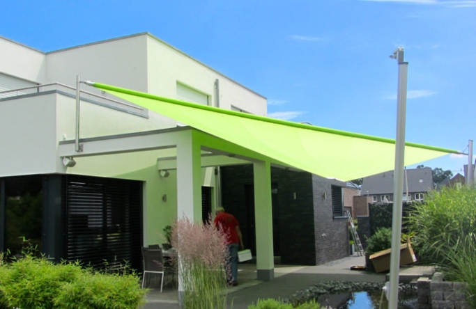 Sonnensegel elektrisch Greven 2M / 2W I. grünes Sonnensegel vor einem weißen Haus