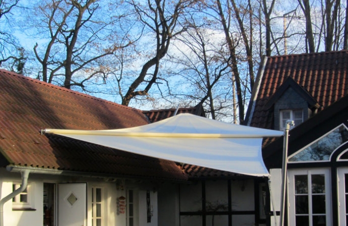 Sonnensegel elektrisch Recklinghausen 1M / 3W in elfenbein vor einem Haus