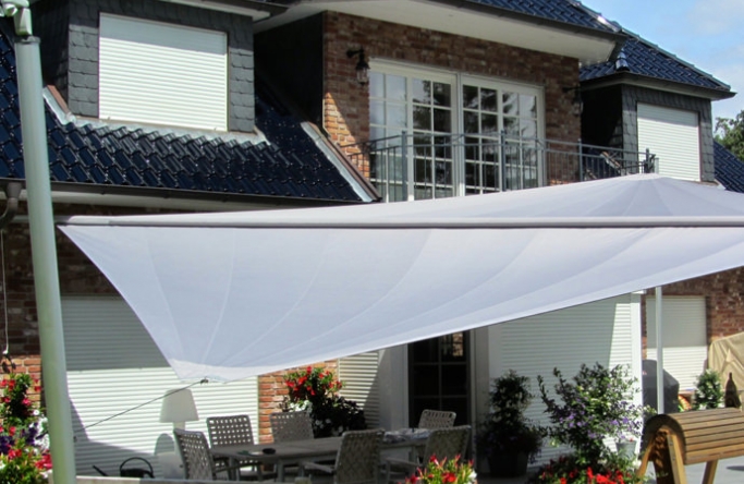 Sonnensegel elektrisch Trittau 3M / 1W II. graues Segel vor einem Haus