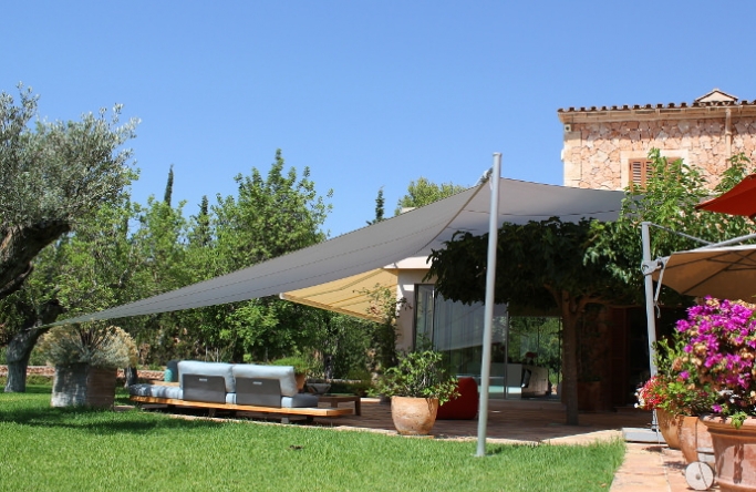 Mallorca - Seitenansicht elektrisches Sonnensegel mit grauem Segeltuch vor Finca