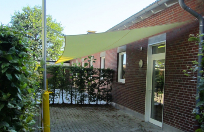 Sonnensegel feststehend Lüdinghausen 2M / 2W gelbes Segel vor einem Haus
