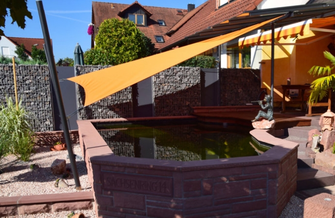 Sonnensegel feststehend Niedernberg 2M / 2W Sonnensegel feststehend Niedernberg 2M / 2W oranges Segel über einen Koiteich